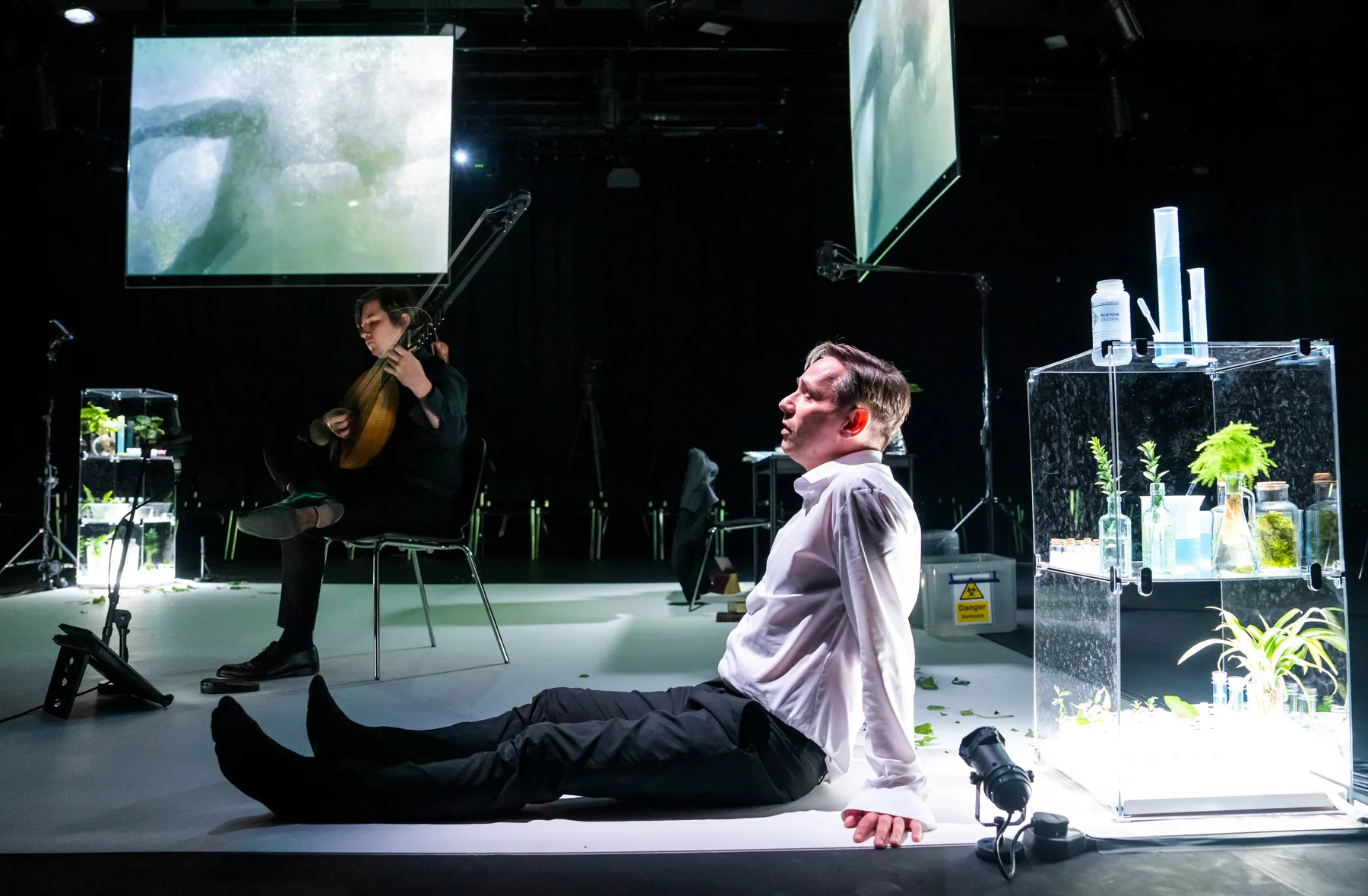 A lutenist performs inside the projected visual world of An Anatomy of Melancholy at the Barbican