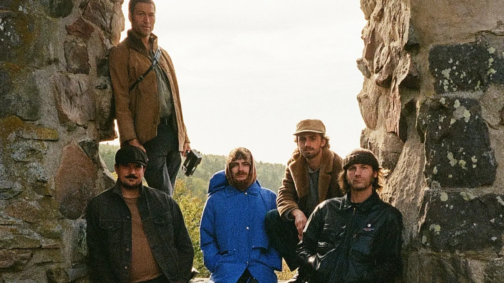 The five members of HORSEBATH standing among weathered stone ruins