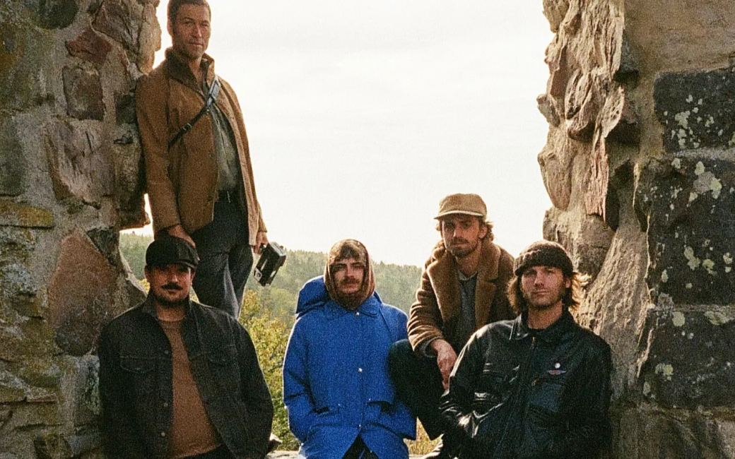 The five members of HORSEBATH standing among weathered stone ruins